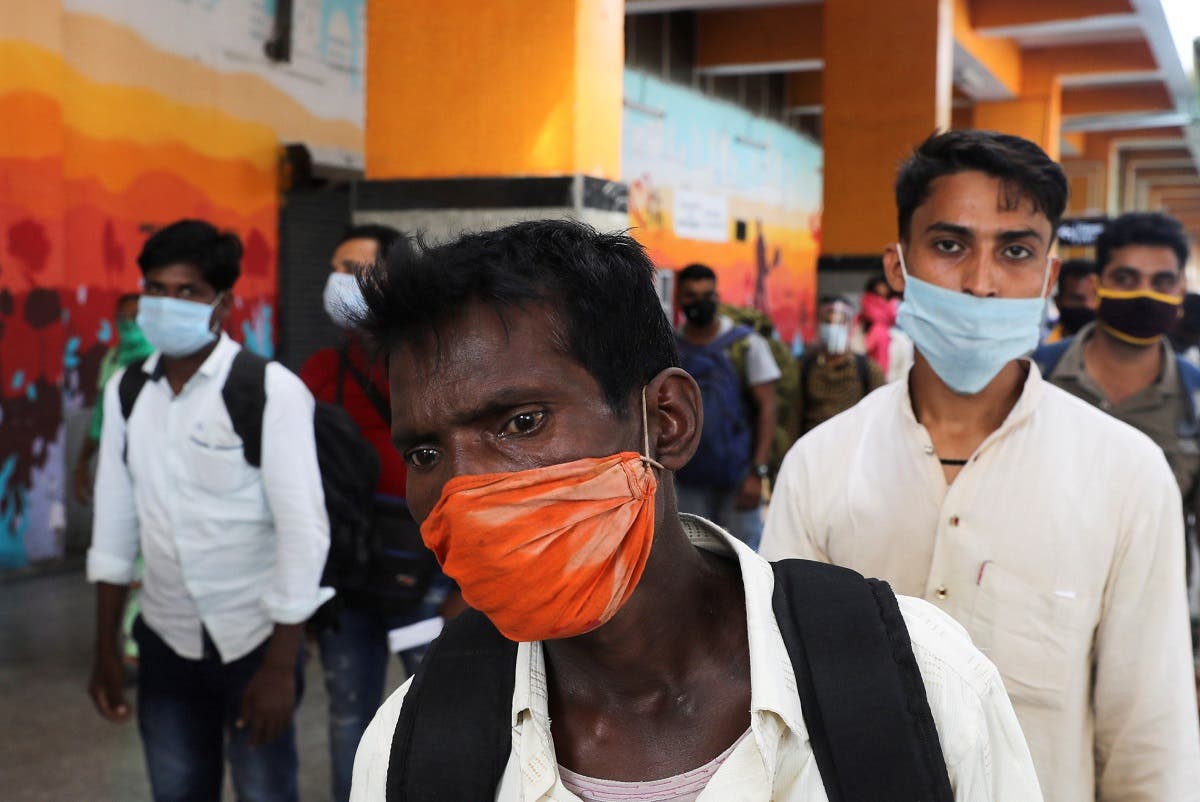 Passengers wearing face masks stand in line to get tested for coronavirus, at a railway station, in New Delhi, India, Oct. 5, 2020. (Reuters)