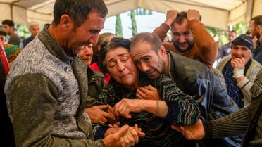 Relatives of a family killed when a rocket hit their home, mourn during their funeral in the city of Ganja, Azerbaijan, on October 17, 2020 during fighting over the breakaway region of Nagorno-Karabakh. (AFP)
