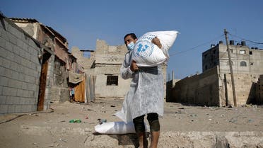 Palestinian refugees receive aid distributed by UNRWA amid the Covid-19 coronavirus disease outbreak, at the United Nations center in Gaza City, Oct. 8, 2020. (AFP)