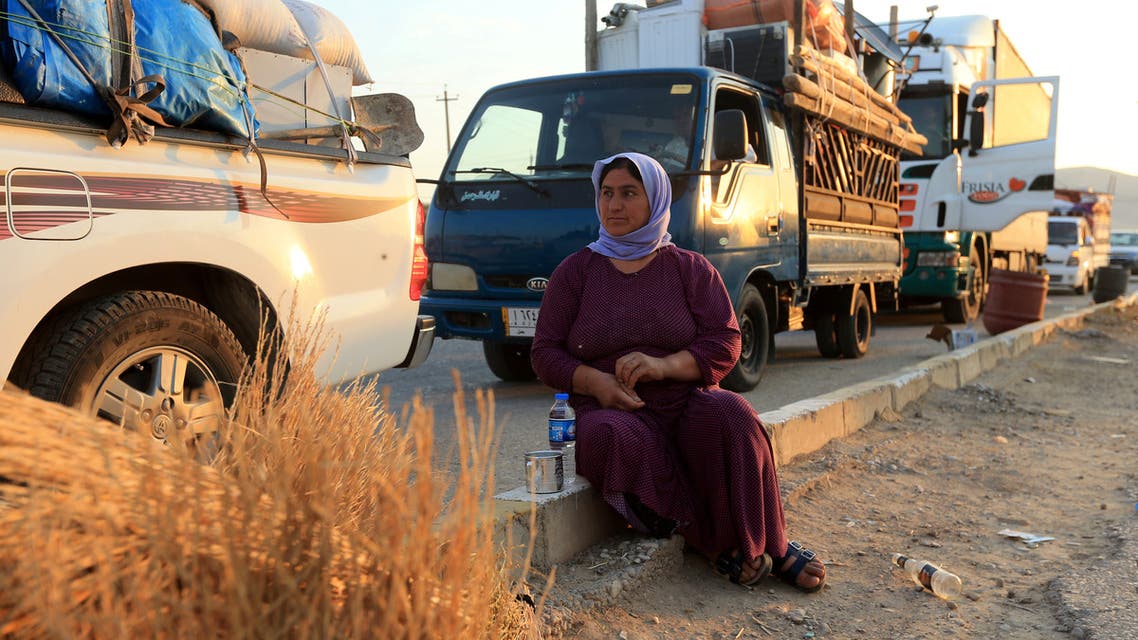  Wife of displaced Yazidi Nayef al-Hamo sits with her neighbours on the road as she heads back to Sinjar following the outbreak of the coronavirus disease (COVID-19) and economic crisis, near Dohuk, Iraq July 3, 2020.  (Reuters)