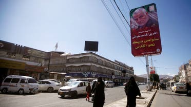 Women pass next to a billboard with posters of Iranian Major-General Qassem Soleimani, head of the elite Quds Force, who was killed in an air strike at Baghdad airport, in Sanaa, Yemen January 9, 2020. Picture taken January 9, 2020. REUTERS/Mohamed al-Sayaghi
