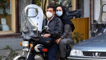 Iranians wear face masks as a COVID-19 coronavirus pandemic precaution, in Iran's capital Tehran on October 14, 2020. (AFP)
