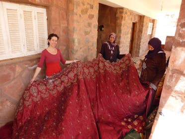 Kirstie Macleod (left) and Selema Gebaly (middle) looking at the material to be embroidered, in Saint Catherine, Sinai, Egypt. (Supplied: Kirstie Macleod)