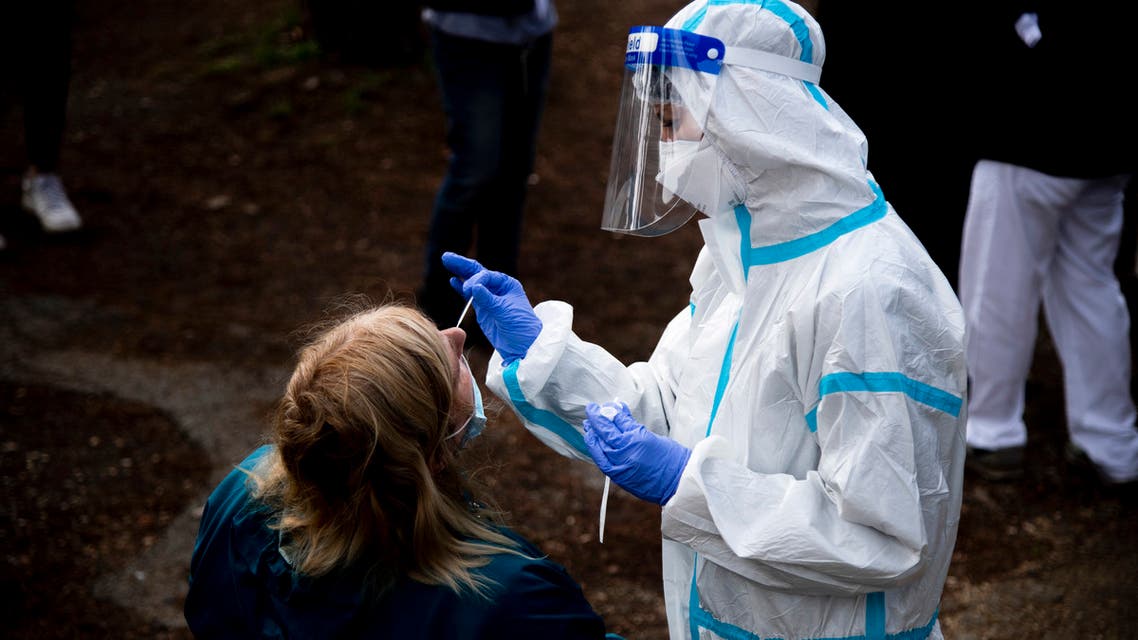 A woman undergoes a swab test for coronavirus at a drive-through testing site of the Santa Maria della Pieta hospital in Rome on October 12, 2020.