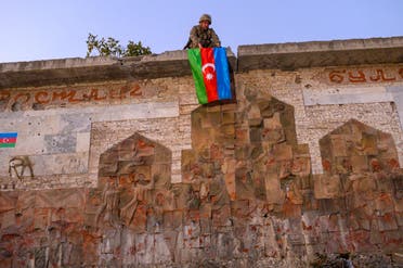 جندي أذربيجاني يرفع علم بلاده في منطقة استعادتها