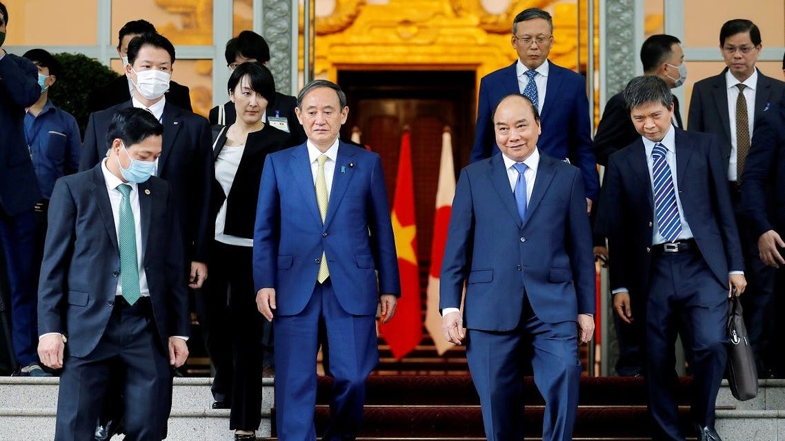 Japanese Prime Minister Yoshihide Suga and his Vietnamese counterpart Nguyen Xuan Phuc walk after a press briefing at the Government Office in Hanoi, Vietnam, October 19, 2020. (Reuters)