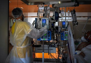 A healthcare worker in protective suit attends a COVID-19 patient at the Intensive Care Unit (ICU) of the Ramon y Cajal Hospital in Madrid on October 15, 2020. (AFP)