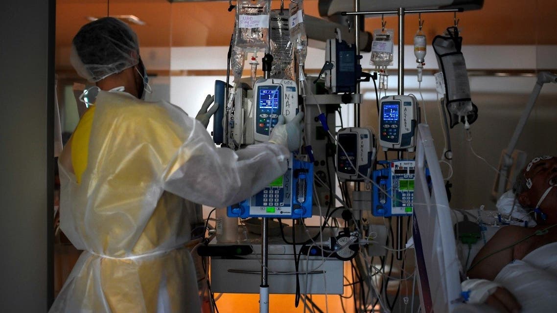 A healthcare worker in protective suit attends a COVID-19 patient at the Intensive Care Unit (ICU) of the Ramon y Cajal Hospital in Madrid on October 15, 2020. (Oscar del Pozo/AFP)