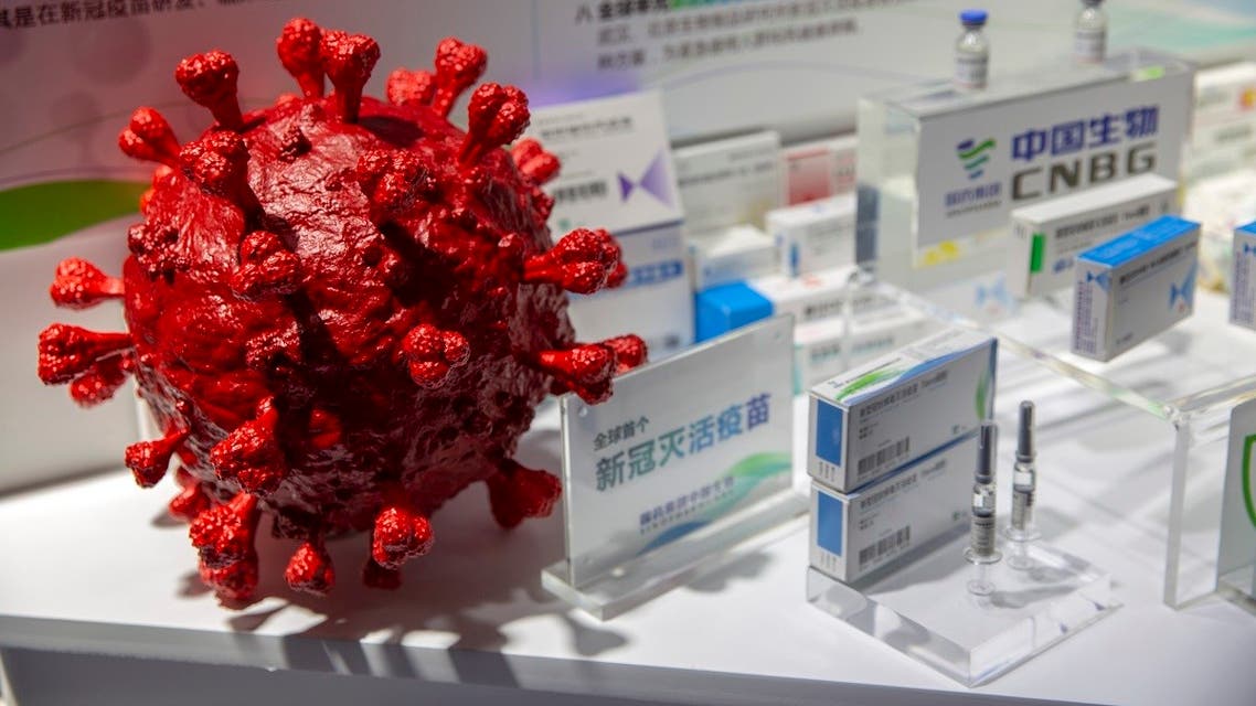 A model of a coronavirus is displayed next to boxes for COVID-19 vaccines at an exhibit by Chinese pharmaceutical firm Sinopharm in Beijing, Sept. 5, 2020. (AP Photo/Mark Schiefelbein)
