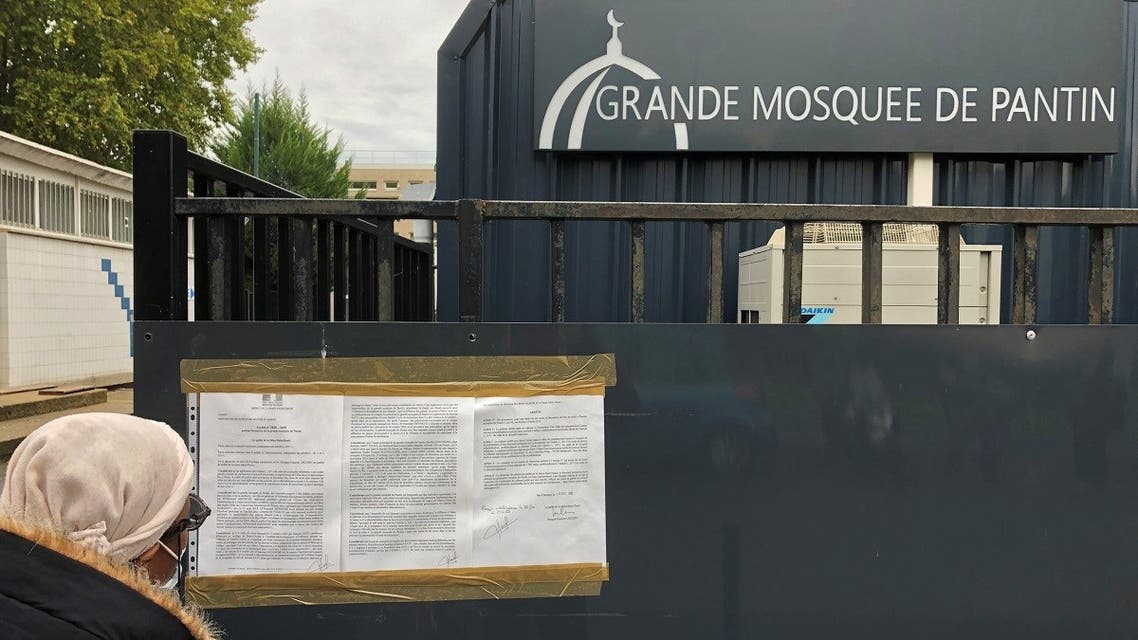 A woman reads a prefectoral decree installed on the entrance gates of the Grand Mosque of Pantin, near Paris, France, on October 20, 2020. (Reuters)