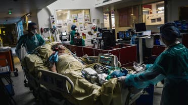 This file photo taken on October 14, 2020 medical staff members transporting a patient at the intensive care unit of the Lariboisiere Hospital of the AP-HP in Paris. (AFP)