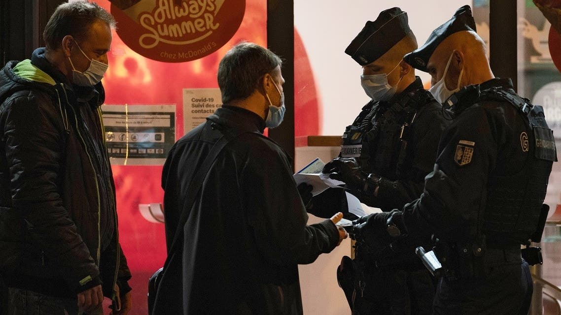 Gendarmes control the derogation of a pedestrian, on October 17, 2020 in Paris, at the start of a nighttime curfew implemented to fight the spread of the COVID-19 pandemic. (AFP)