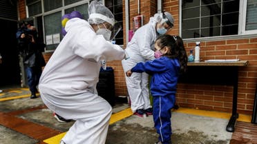 A teacher wearing personal protective equipment checks a child's temperature during the opening of the kindergartens in Bogota, on September 23, 2020 amid the coronavirus pandemic. (AFP)
