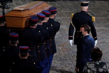 French President Emmanuel Macron watches the coffin of slain teacher Samuel Paty being carried in the courtyard of the Sorbonne university during a national memorial event, in Paris, France October 21, 2020. (Francois Mori/Pool via Reuters)