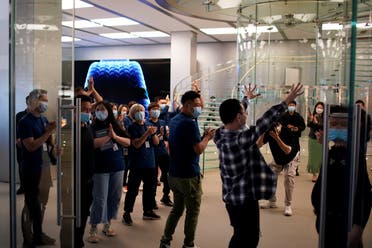A man reacts while entering at an Apple Store before Apple’s 5G new iPhone 12 go on sale, as the coronavirus disease (outbreak continues in Shanghai, China, on October 23, 2020. (Reuters)