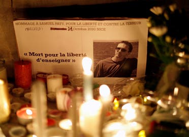 Candles are lit at a makeshift memorial as people gather to pay homage to Samuel Paty, the French teacher who was beheaded on the streets of the Paris suburb of Conflans-Sainte-Honorine, as part of a national tribute, in Nice, France, on October 21, 2020. (Reuters)