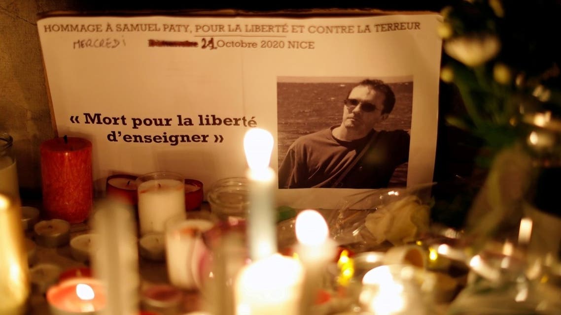 Candles are lit at a makeshift memorial as people gather to pay homage to Samuel Paty, the French teacher who was beheaded on the streets of the Paris suburb of Conflans-Sainte-Honorine, as part of a national tribute, in Nice, France, on October 21, 2020. (Reuters)