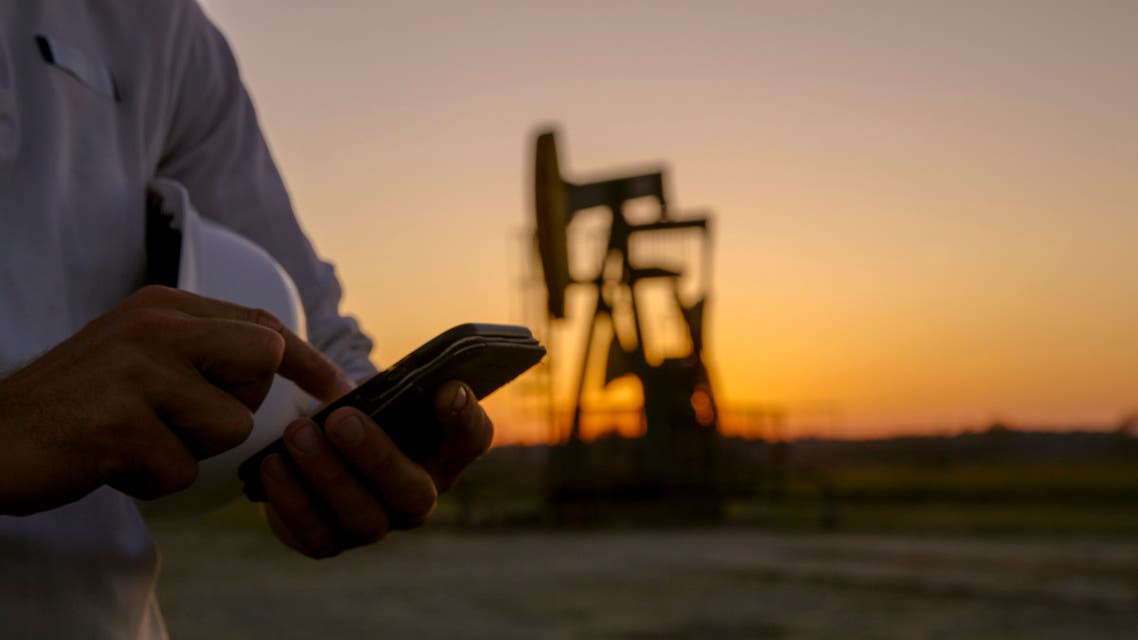 iStock Close up of smart phone against pumpjack