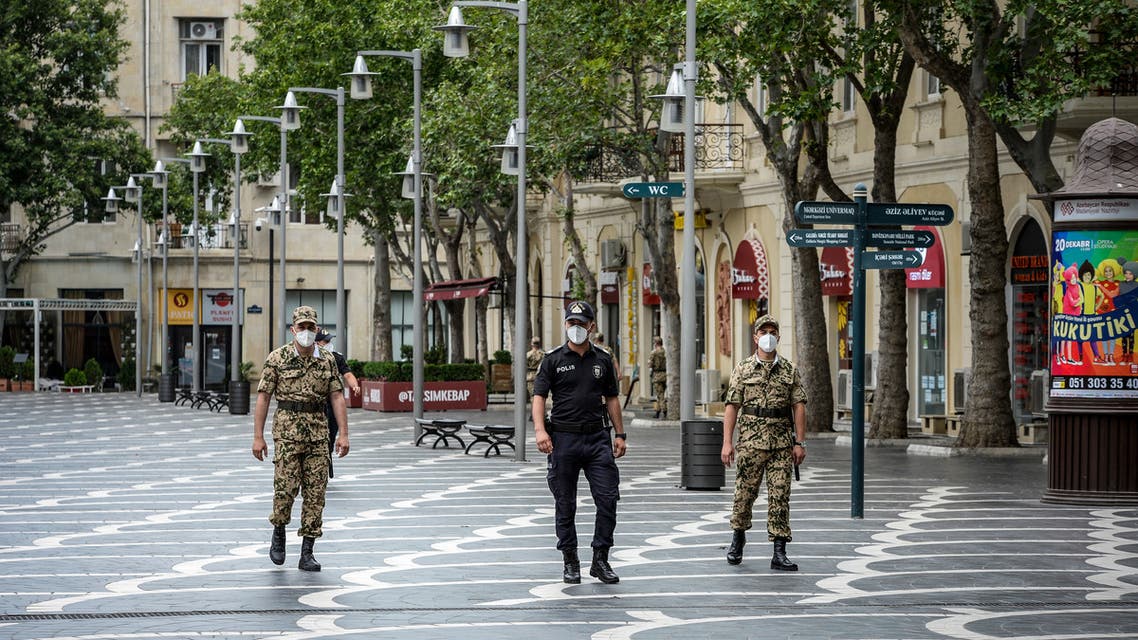Police officers wearing protective face masks patrol a deserted street in Baku on June 21, 2020, amid the outbreak of COVID-19, caused by the novel coronavirus. Anxiety mingled with anger in Azerbaijan as the Caspian nation reinstated on June 21, 2020 a tight coronavirus lockdown to contain the surge in infections that followed the easing of restrictions weeks ago. Azerbaijanis will now only be allowed to leave home once a day for a maximum of two hours after receiving permission via text message from the authorities, Prime Minister Ali Asadov said in a statement.