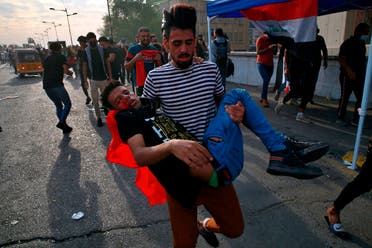 An injured protester is rushed to a hospital during clashes with security forces on the closed Joumhouriya Bridge that leads to the Green Zone government areas, in Baghdad, Iraq, Sunday, Oct. 25, 2020. (AP/Khalid Mohammed)