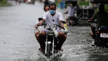 A man driving a bike amid Typhoon Molave in Pampanga province, northern Philippines, Monday, Oct. 26, 2020. (AP)