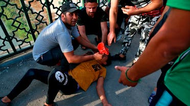 An Iraqi man receives first aid after Iraqi security forces fired tear gas during anti-government protests in Baghdad, Iraq, Sunday, Oct. 25, 2020. (AP)