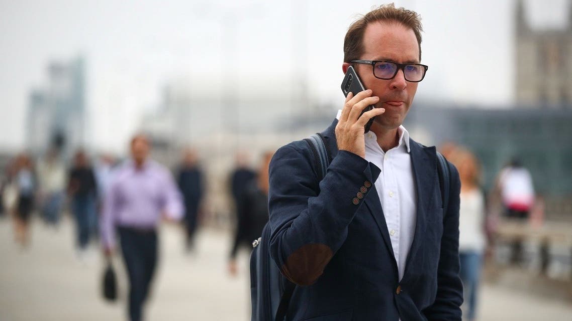 A man talks on his mobile phone as commuters walk across the London Bridge during the morning rush hour, amid an outbreak of the coronavirus disease, in London, Britain. (Reuters)