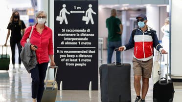 A file photo shows passengers wearing protective face masks walk at Fiumicino Airport in Rome, Italy, June 30, 2020. (Reuters/Guglielmo Mangiapane)