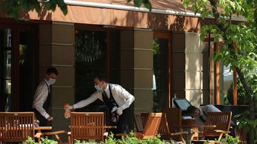 Waiters wearing protective face masks work at a cafe as restaurants and cafes reopen summer terraces in Moscow. (Reuters)