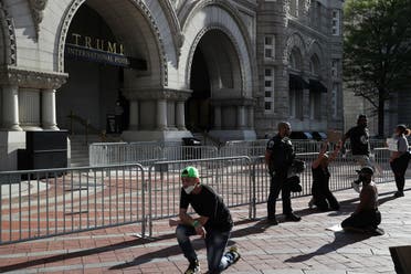 Protesters kneel in front of law enforcement officers at the Trump International Hotel in Washington, DC, May 31, 2020. (Reuters)