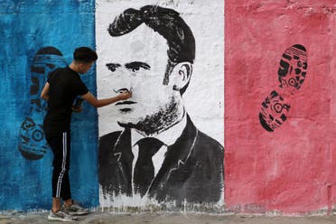A Palestinian artist paints an anti-French President Emmanuel Macron mural to protest against the publications of a cartoon of Prophet Mohammad in France and Macron's comments, in Gaza City. (Reuters)
