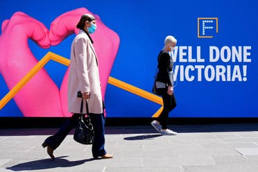 People walk past a 'Well Done' sign after coronavirus restrictions were eased for the state of Victoria, in Melbourne, Australia, on October 28, 2020. (Reuters)