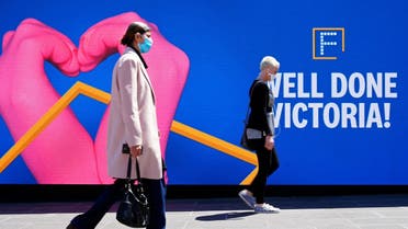 People walk past a 'Well Done' sign after coronavirus restrictions were eased for the state of Victoria, in Melbourne, Australia, October 28, 2020. (Reuters)