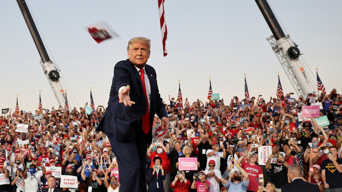 FILE PHOTO: U.S. President Donald Trump throws a face mask from the stage during a campaign rally, his first since being treated for the coronavirus disease (COVID-19), at Orlando Sanford International Airport in Sanford, Florida, U.S., October 12, 2020. REUTERS/Jonathan Ernst/File Photo