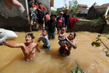 A resident gets money from a volunteer at a flooded area in Quang Binh province, Vietnam October 23, 2020. (Reuters)