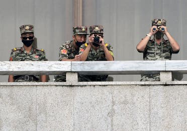 جنود من كوريا الشمالية يراقبون المنطقة العازلة التي تفصل بين الكوريتين (أرشيفية)