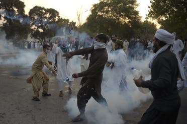 Pakistani protesters return teargas shells during a demonstration in Islamabad on October 30, 2020, following French President Emmanuel Macron's comments over the Prophet Mohammed caricatures. (AFP)