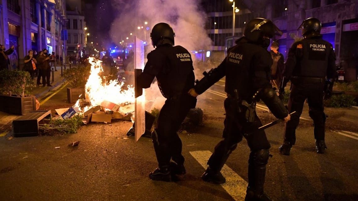 Members of the Catalan regional police force Mossos d'Esquadra take position next to burning trash set on fire by protesters during a demonstration against new coronavirus restrictions in Barcelona on October 30, 2020. (AFP)