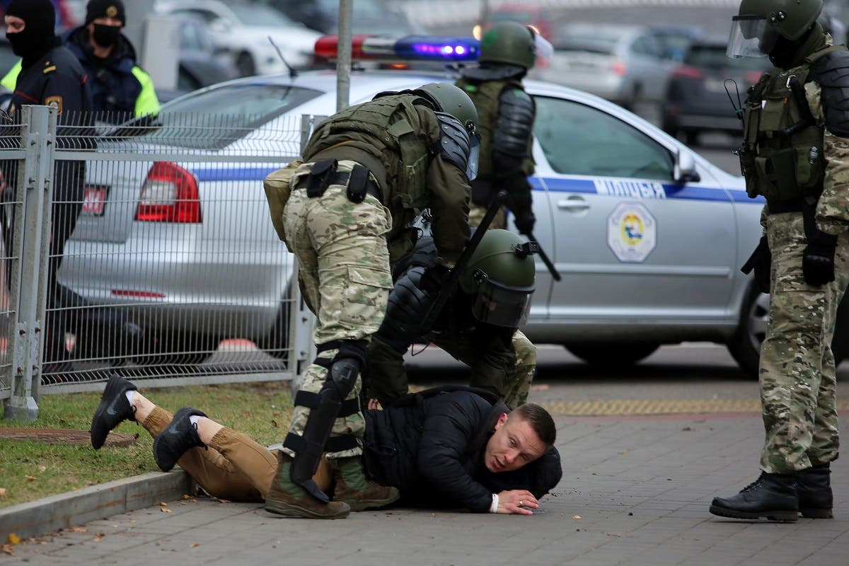 Law enforcement officers detain a man during a march of opposition supporters from central Minsk to a site of Stalin-era executions just outside the capital on November 1, 2020. (Stringer/AFP)