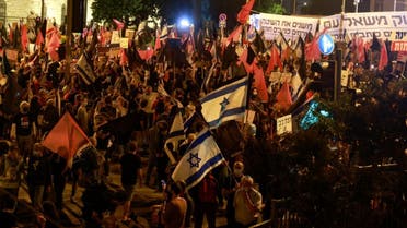 Protesters wave flags during a demonstration near the residence of Israeli Prime Minister Benjamin Netanyahu in Jerusalem, on October 31, 2020, to demand his resignation over his corruption cases. (AFP)
