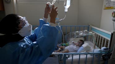 A nurse wearing a protective suit and mask tends to a baby who is affected by the coronavirus disease (COVID-19), at Hazrate Ali Asghar Hospital, in Tehran, Iran September 27, 2020. Picture taken September 27, 2020. Majid Asgaripour/WANA (West Asia News Agency) via REUTERS ATTENTION EDITORS - THIS IMAGE HAS BEEN SUPPLIED BY A THIRD PARTY.