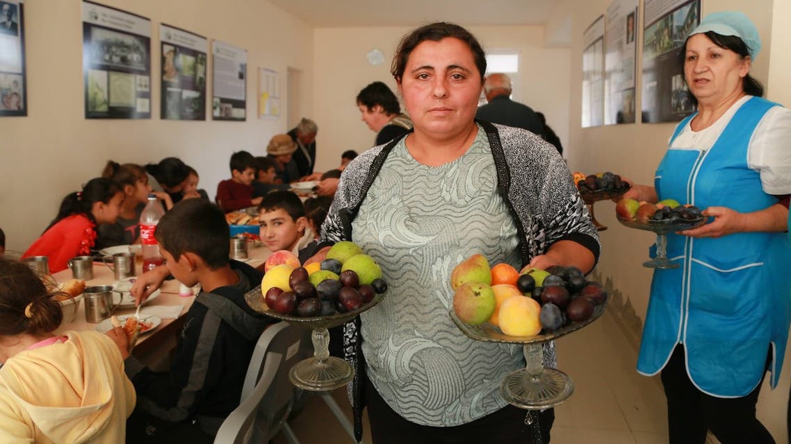 A woman holds fruit at the Armenian camp hosted by the Displacement Camp Armenian Missionary Association of America. (Supplied by the organization)