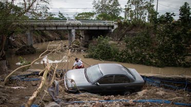 A man sits beside a car, washed away by floods caused by Typhoon Goni, in Barangay San Isidro, Batangas City, Philippines, on November 2, 2020. (Reuters)