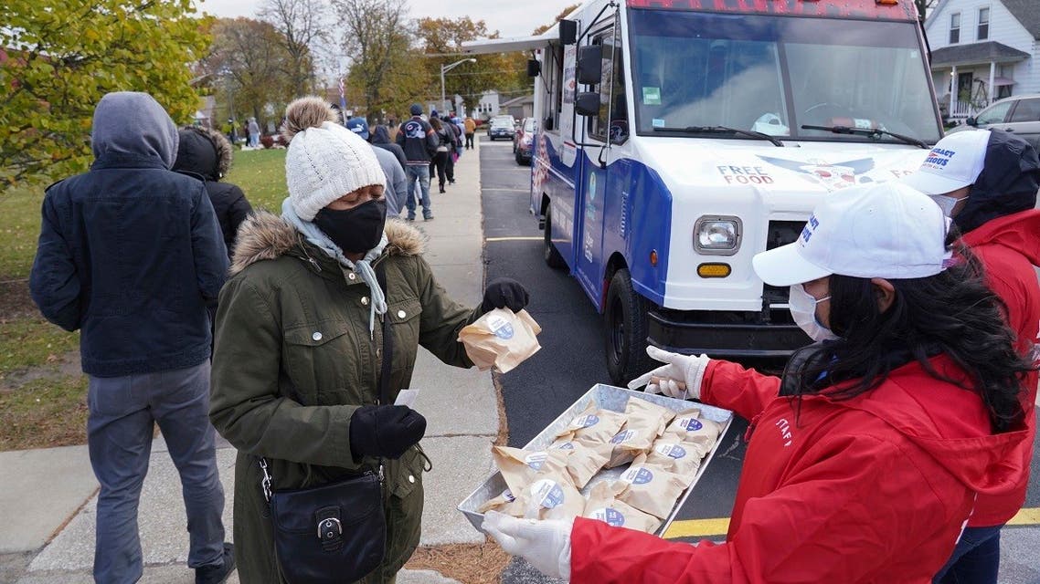 A food truck staff worker distributes free snacks as long lines form in front of the Pizza to the Polls and Uber Eats food truck, Nov. 1, 2020 in Illinois. (AP)