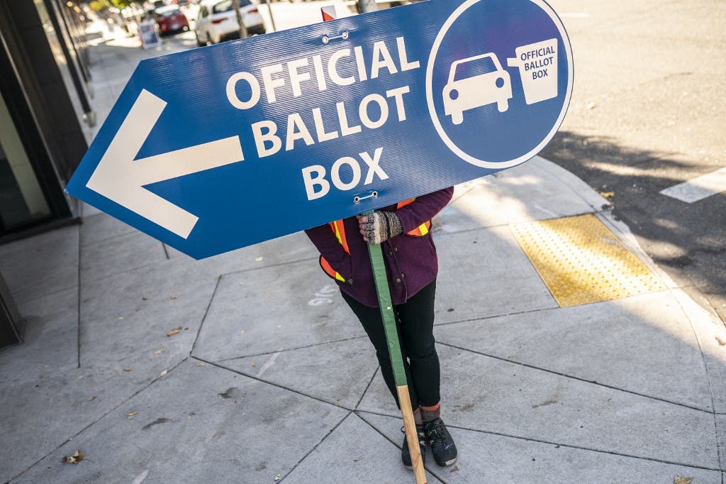 An election worker directs voters to a ballot drop off location on November 2, 2020 in Portland, Oregon. (AFP)
