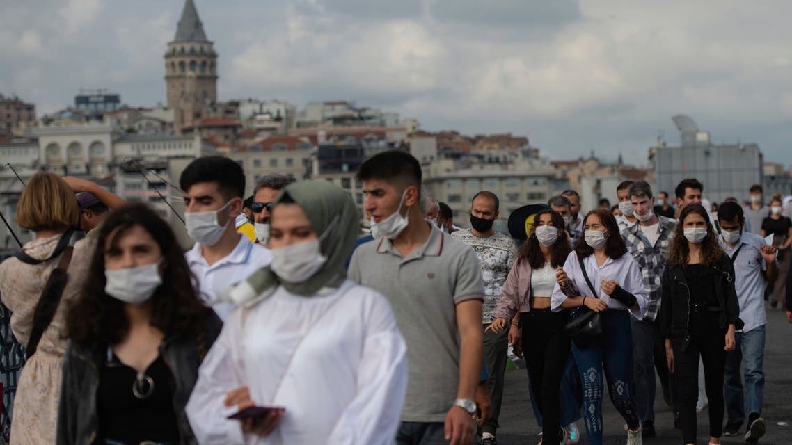 people wearing masks for protection against the spread of coronavirus, walk over Eminonu bridge in Istanbul, Friday, Sept. 11, 2020. (AP)