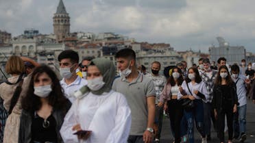 People wearing masks for protection against the spread of coronavirus, walk over Eminonu bridge in Istanbul, Friday, Sept. 11, 2020. (AP)