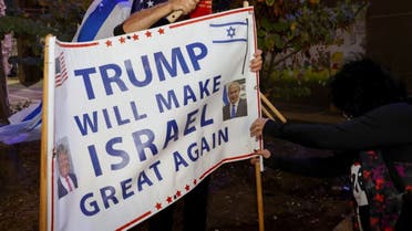 Israeli supporters of US President Donald Trump hammer a sign into the ground during a rally in the northern Israeli city of Karmiel near Haifa on November 3, 2020, to express their support for him during the US presidential election. (AFP)