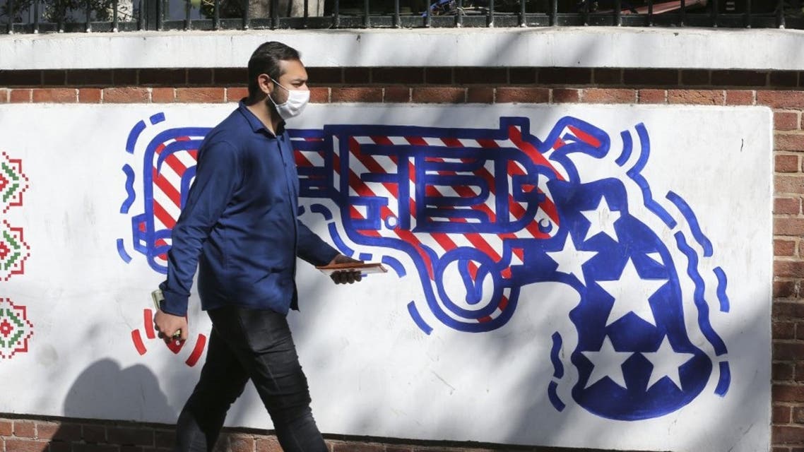A man walks past a mural painted on the outer walls of the former US embassy in the Iranian capital Tehran, on September 29, 2020.