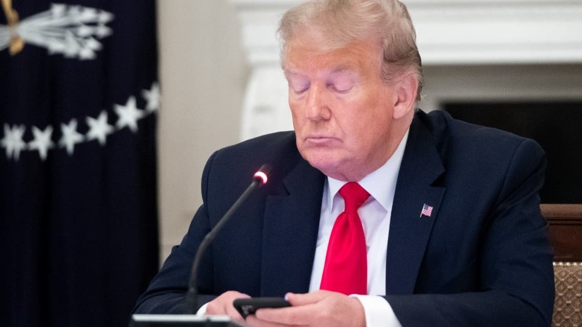 US President Donald Trump uses his cellphone in the State Dining Room of the White House in Washington, DC, June 18, 2020. (AFP)